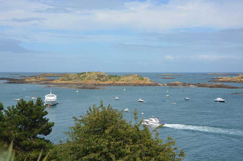 Vue panoramique des îles Chausey avec bateaux naviguant sur une mer calme en Normandie