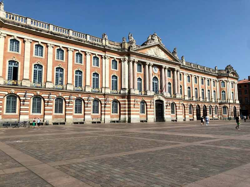 Façade du Capitole de Toulouse sous un ciel bleu, emblème architectural de la ville rose en Occitanie