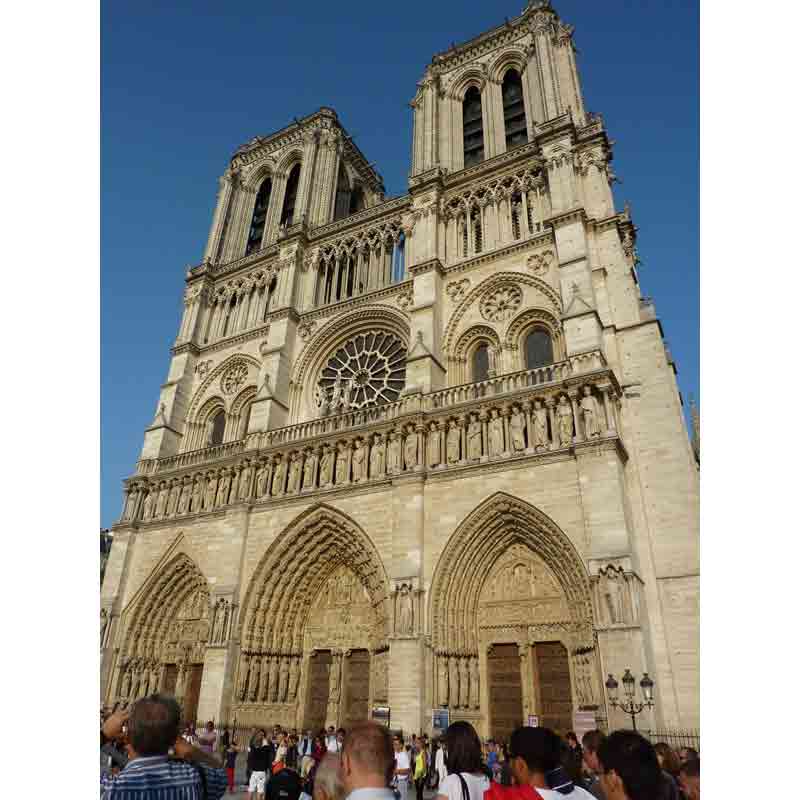 Façade de la cathédrale Notre-Dame de Paris avec ses tours, ses portails sculptés et les visiteurs sur le parvis