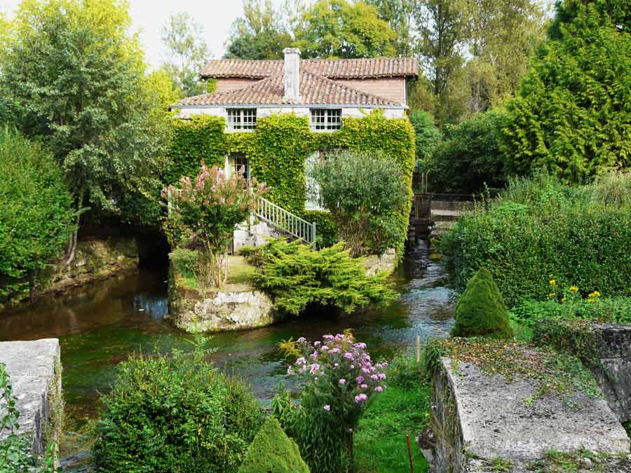 Le moulin de Bourdeilles posé sur la Dronne, entouré de verdure au cœur du Périgord Vert