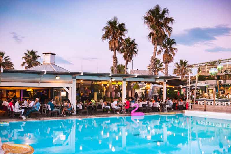 piscine entourée de tables avec des personnes qui dinent au restaurant Sport Beach, proche de l’escale Borely à Marseille