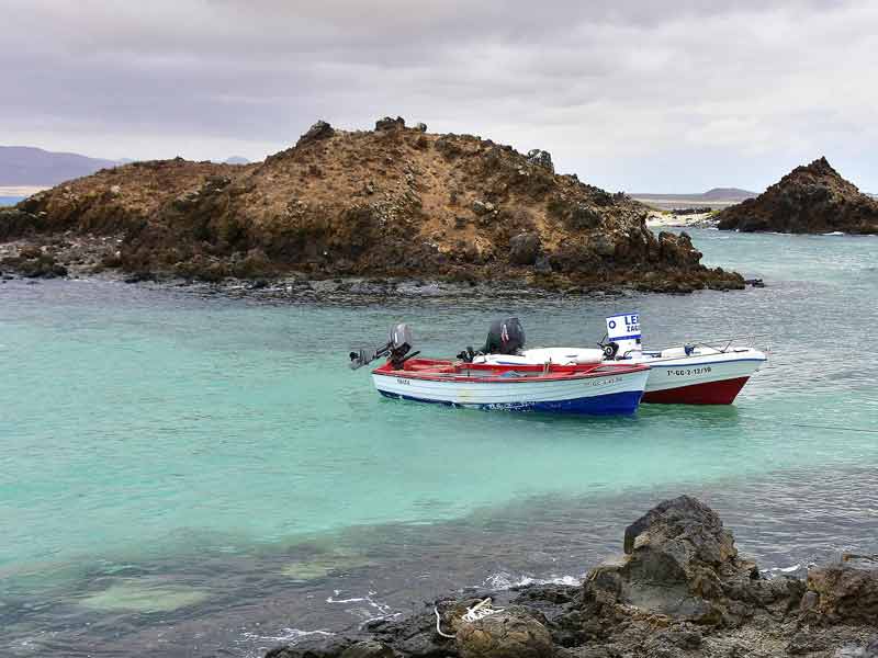 Bateau de pêche sur les eaux turquoise de l’île de Lobos, réserve naturelle au large de Fuerteventura