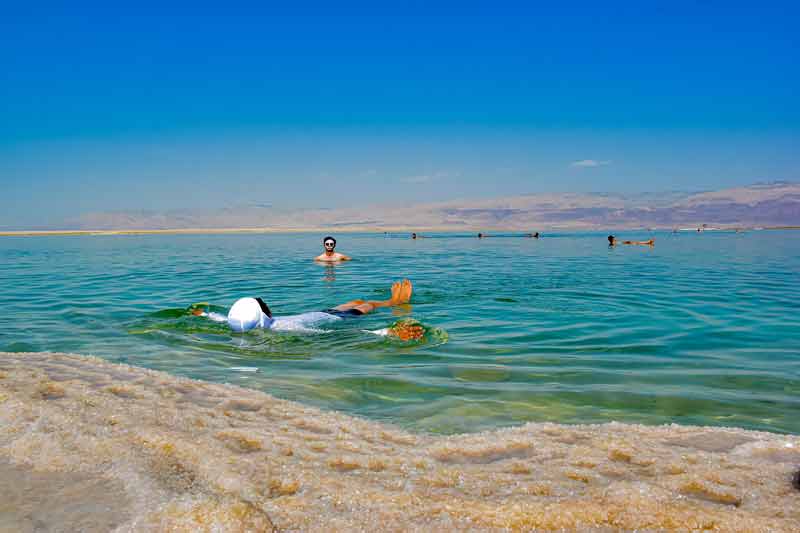 Touristes qui flottent dans la mer Morte