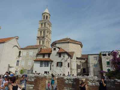 Vue sur le clocher de la cathédrale Saint-Domnius et les maisons de pierre du palais de 
												Dioclétien à Split, en Croatie, avec des visiteurs profitant du site historique