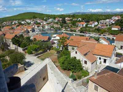 Vue panoramique sur les toits en tuiles rouges et les ruelles fleuries du village de Hvar, en Croatie, 
												entouré de collines verdoyantes