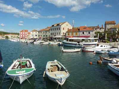 Bateaux de pêche amarrés dans le port pittoresque de Hvar, en Croatie, avec des façades colorées en pierre 
												en arrière-plan et une ambiance méditerranéenne