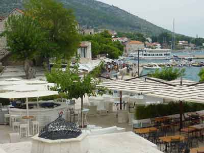 Terrasses de cafés et vue animée sur le front de mer de Bol, sur l'île de Brač en Croatie, avec des promeneurs 
												et des bateaux dans le port