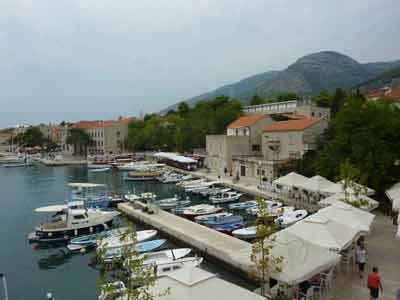 Vue panoramique du port de Bol sur l'île de Brač lors d'un road trip Croatie, avec ses bateaux amarrés, 
												ses maisons de pierre et les montagnes en toile de fond