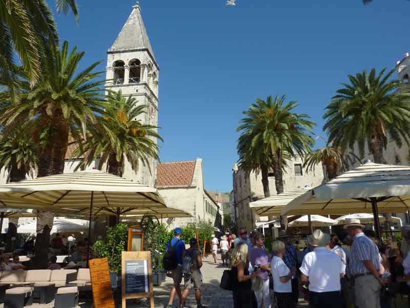 Grande place ensoleillée avec terrasses et clocher de la cathédrale de Trogir en arrière-plan