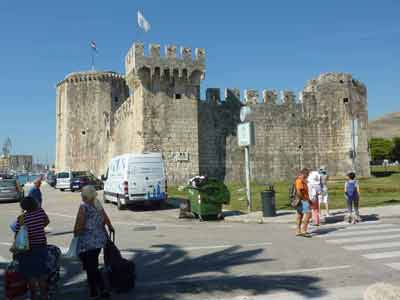Forteresse médiévale Kamerlengo à Trogir avec passants et véhicules devant les remparts