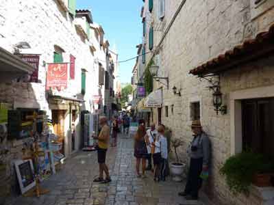 Ruelle pavée bordée de maisons en pierre et de petites boutiques dans le centre historique de Trogir