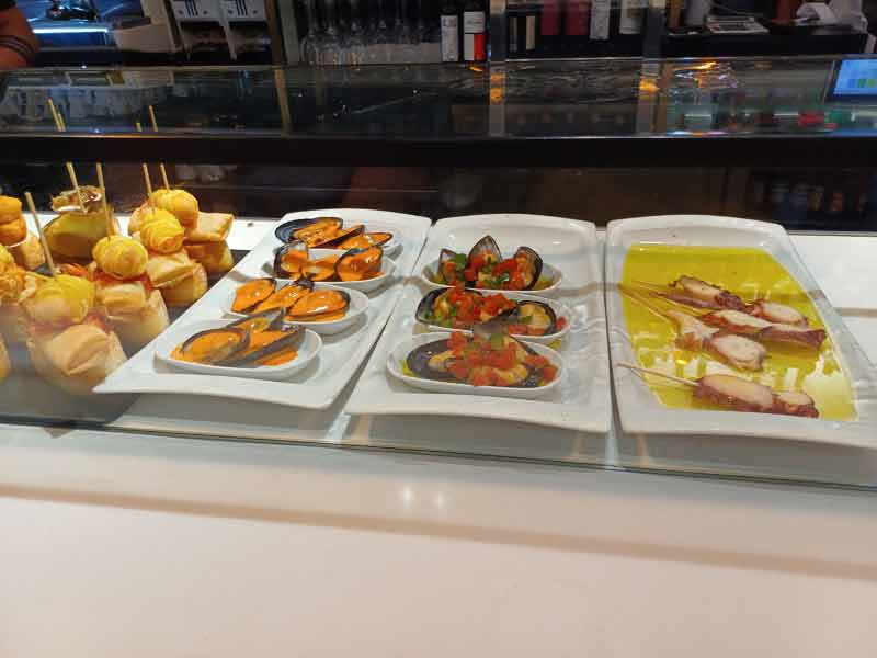 Comptoir de pintxos avec moules, poulpe et brochettes garnies dans un bar de la vieille ville de Saint-Sébastien