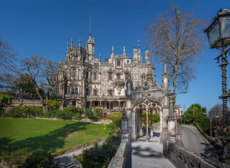Façade gothique et entrée monumentale de la Quinta da Regaleira à Sintra sous un ciel bleu