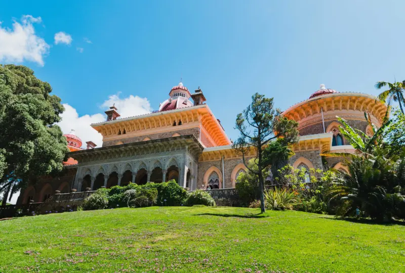 Façade exotique du Palais de Monserrate à Sintra entouré de jardins verdoyants sous un ciel bleu
