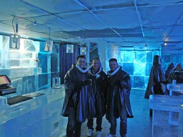 3 clients du Icebar prenant la pose devant le comptoir du bar