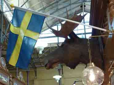 Drapeau suédois et tête d'élan empaillée devant un stand de boucher/charcutier (Östermalms Saluhall)