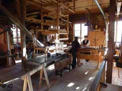 Artisan en costume d’époque travaillant le bois dans un atelier d'époque