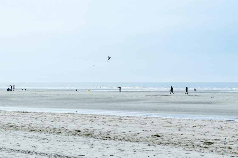 Grande plage de sable fin au Touquet-Paris-Plage avec promeneurs et cerf-volant