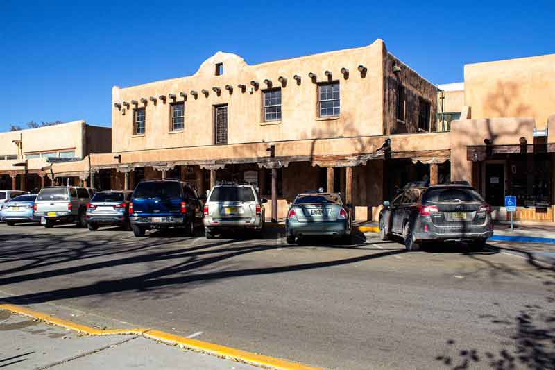 Bâtiments en adobe typiques du centre-ville de Taos, Nouveau-Mexique, avec voitures garées devant les boutiques