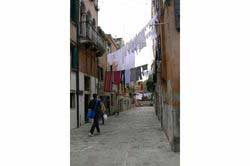 Linge suspendu en hauteur entre des murs dans une rue du quartier du Castello, Venise (Italie)