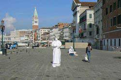 Spectacle de rue durant lequel un homme simule l'immobilité totale d'une statue le long du quai degli Schiavoni à Venise