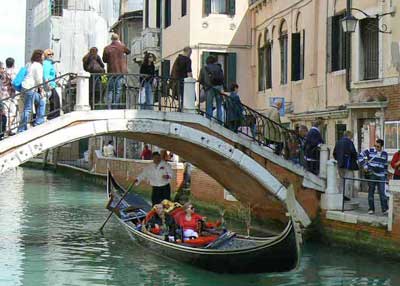 Gondole qui passe sous un pont  Venise