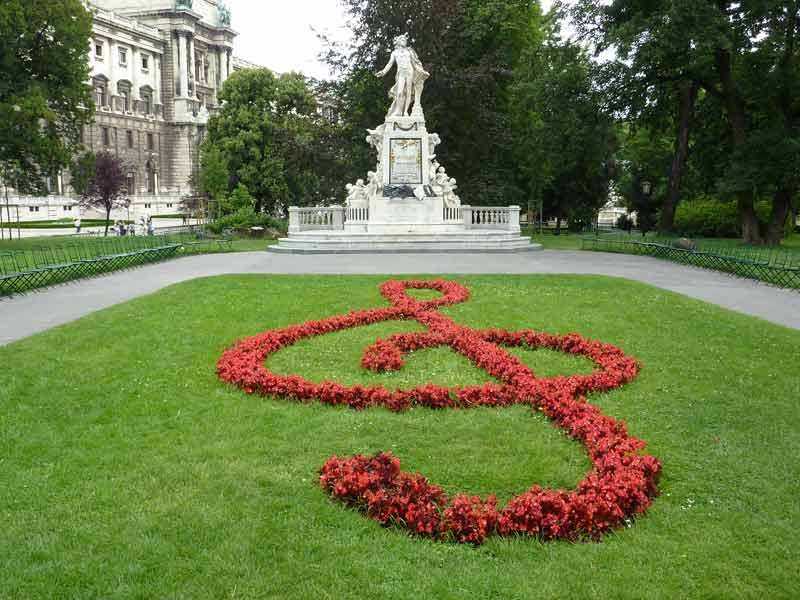 Statue de Mozart mise en valeur par un parterre de fleurs en forme de clé de sol dans le burggarten (Vienne, Autriche)