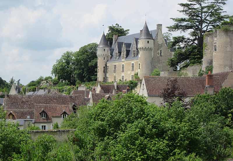 Vue pittoresque du château de Montrésor, avec ses tours et ses remparts en pierre surplombant un village aux toits de tuiles entouré de verdure