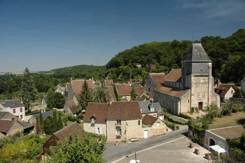 Vue panoramique du village de Lavardin, avec ses maisons en pierre aux toits de tuiles, son église imposante et son cadre 
								verdoyant, sous un ciel dégagé