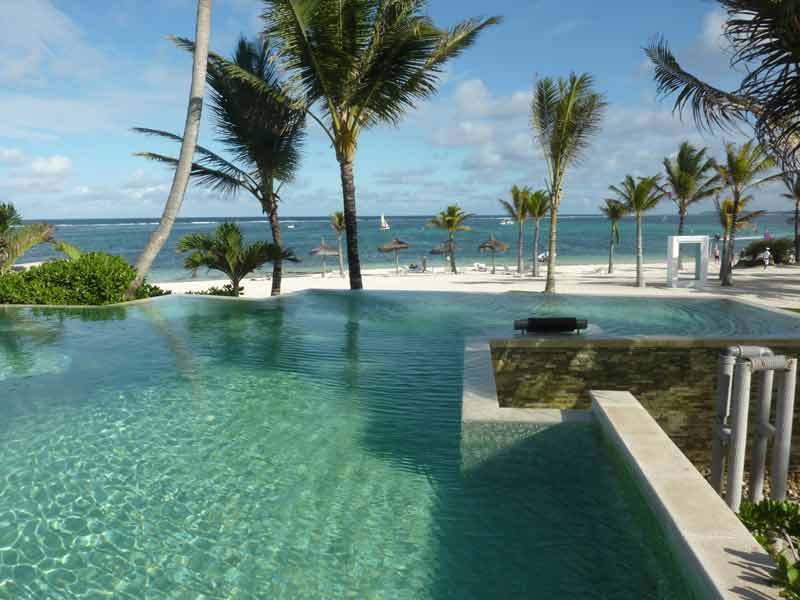 Piscine à débordement dans un hôtel de luxe à l’île Maurice, vue sur l’océan Indien et palmiers tropicaux