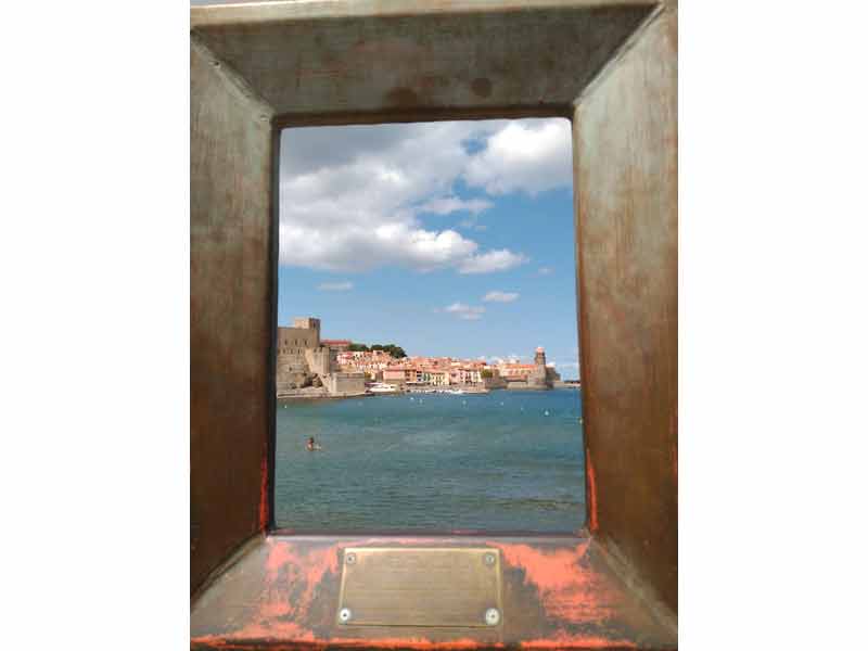 Vue sur Collioure depuis la mer, avec le château royal, les maisons colorées du village et la Méditerranée au premier plan