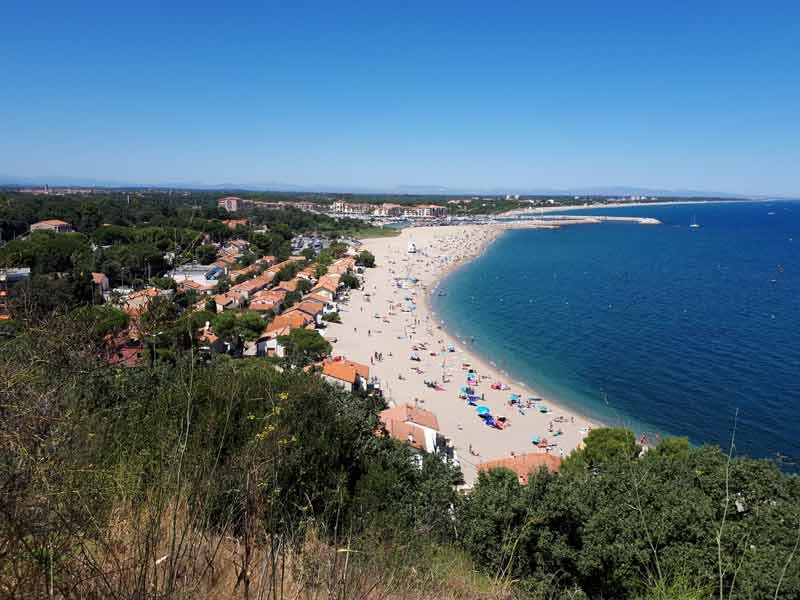 Vue panoramique sur la plage du Racou à Argelès-sur-Mer, avec le sable, la Méditerranée et les maisons du littoral