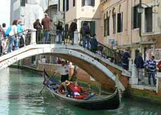 Gondole qui passe sous un pont à Venise