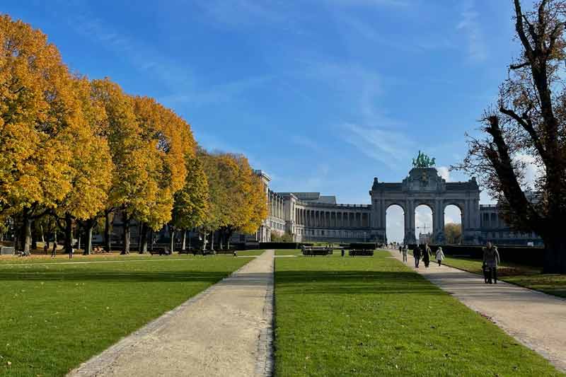 Promenade dans le parc du Cinquantenaire à Bruxelles en été, avec vue sur l’arc de triomphe et les allées arborées