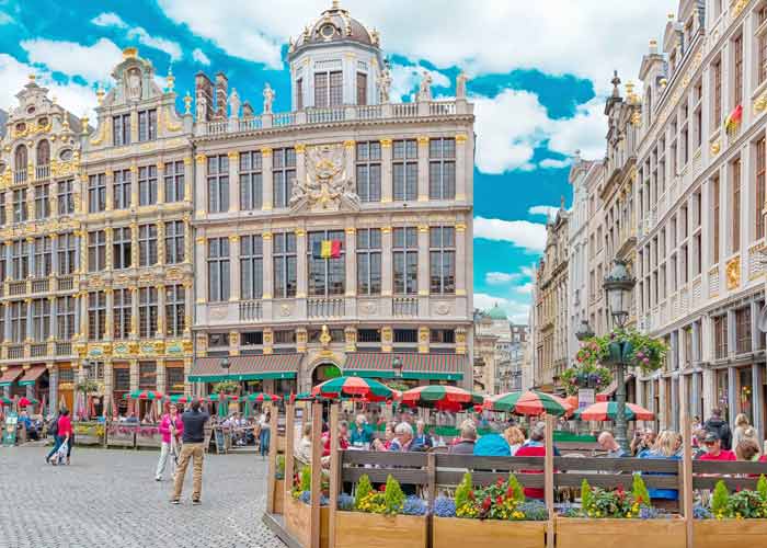 Terrasses animées et façades baroques sur la Grand-Place de Bruxelles un samedi ensoleillé