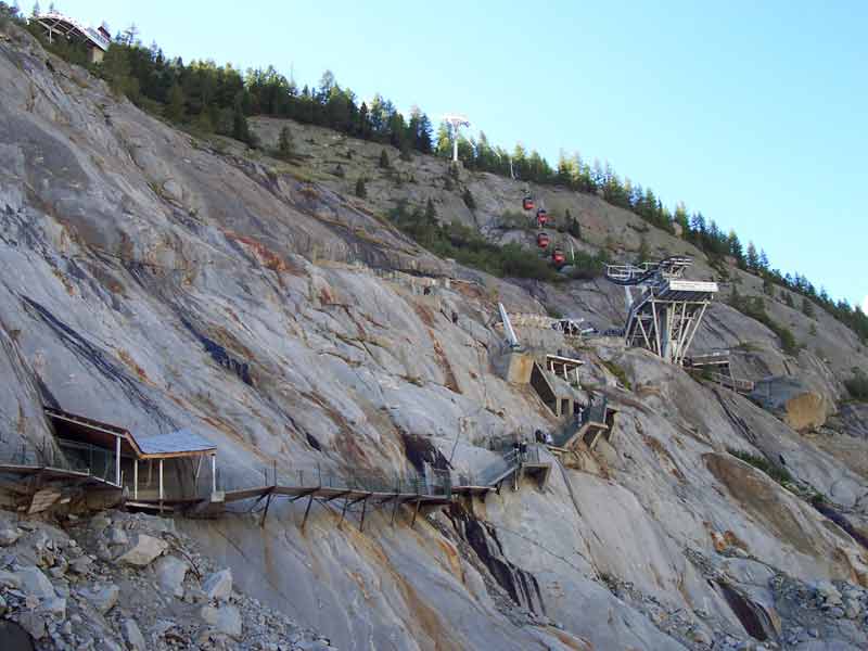 Escaliers métalliques et télécabine descendant vers la Mer de Glace, illustrant le recul du glacier au site du Montenvers