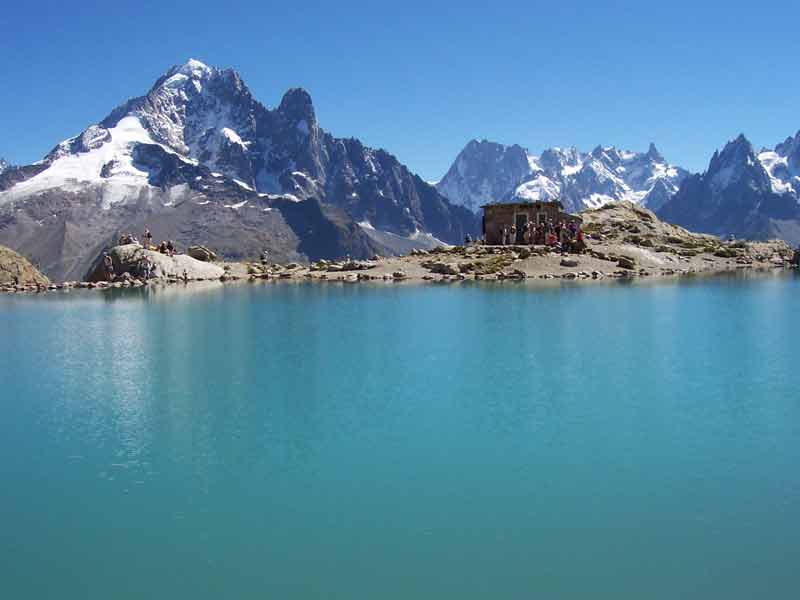Lac Blanc aux eaux turquoise face au massif du Mont-Blanc avec le refuge du lac Blanc au bord du rivage