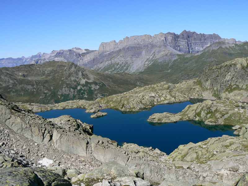 Vue sur le lac cornu depuis les hauteurs des Aiguilles Rouges, entourés de roches et de crêtes alpines