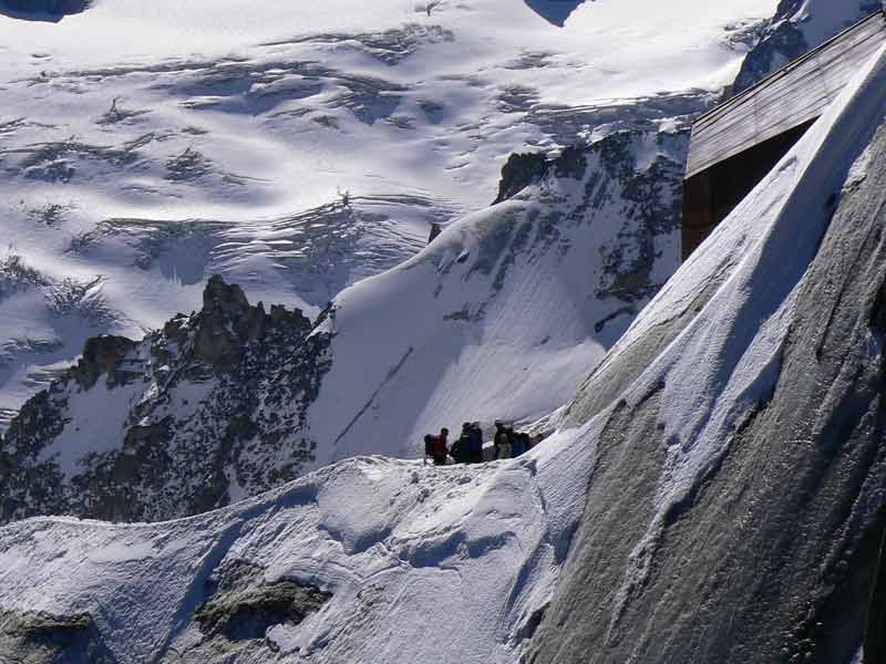 Alpinistes encordés au départ d’une course depuis l’Aiguille du Midi face aux glaciers