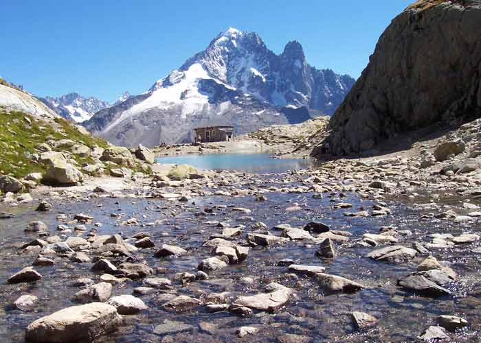 Ruisseau alpin menant au lac Blanc face aux sommets enneigés du massif du Mont-Blanc dans la réserve des Aiguilles Rouges à Chamonix