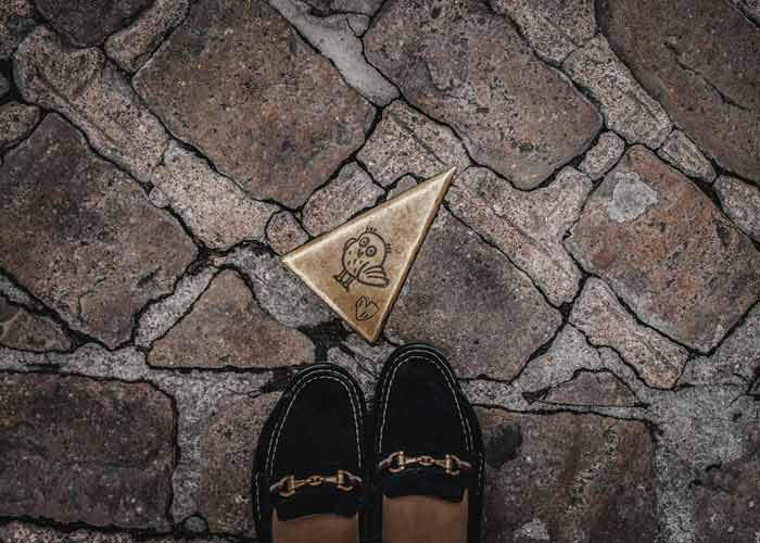 Clou en bronze en forme de triangle avec une chouette gravée, sur le parcours de la chouette à Dijon