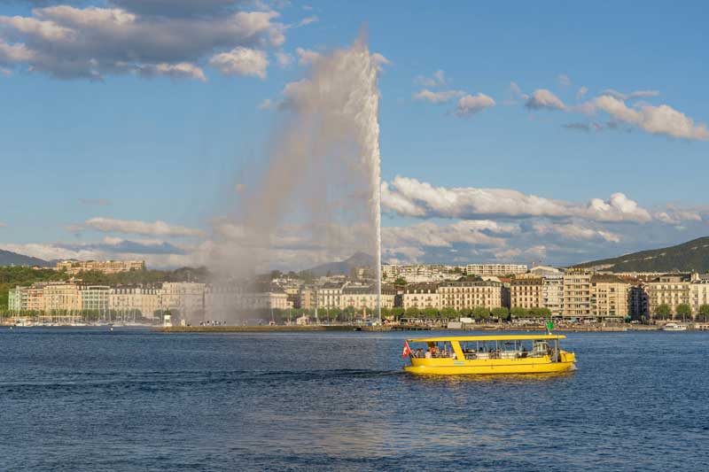 Jet d’eau de Genève sur le lac Léman avec bateau jaune au premier plan, un incontournable à voir quand on cherche que faire à Genève