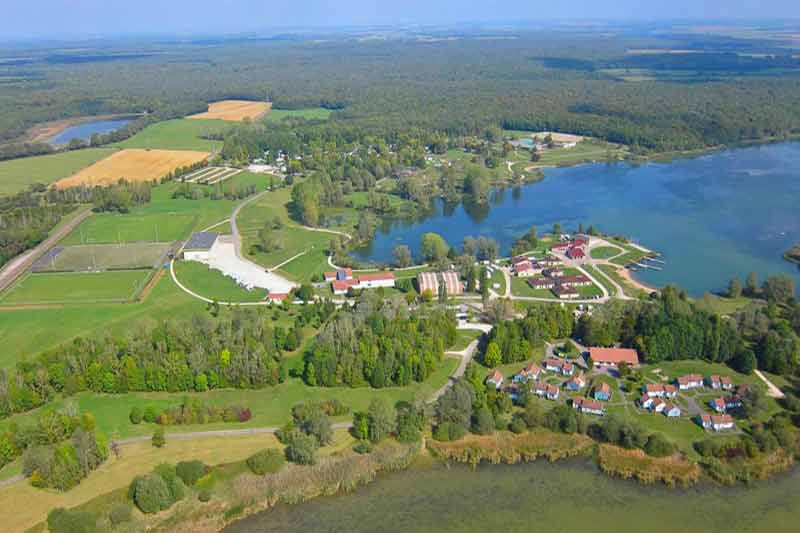 Vue aérienne du lac de Madine en Lorraine, avec Madine 2 au fond (camping et centre équestre) et Madine 3 au premier plan (stades, 
								gymnases, école de voile, village de vacances)