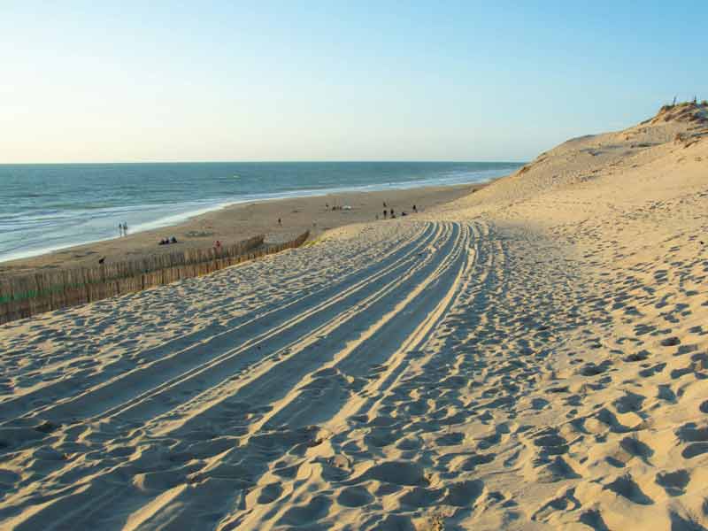 Hourtin plage, trace de roues dans le sable avec vue sur l'océan Atlantiques et des dunes de sable (parc naturel régional du Médoc)