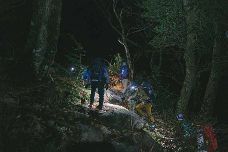Randonnée nocturne en forêt à Méribel, avec lampes frontales et sac à dos