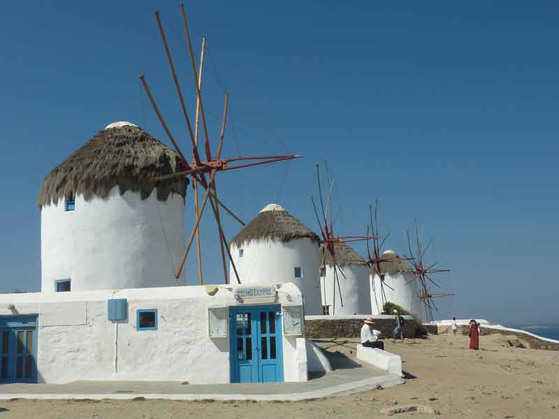 Les célèbres moulins à vent de Mykonos surplombant la mer Égée sous un ciel bleu éclatant