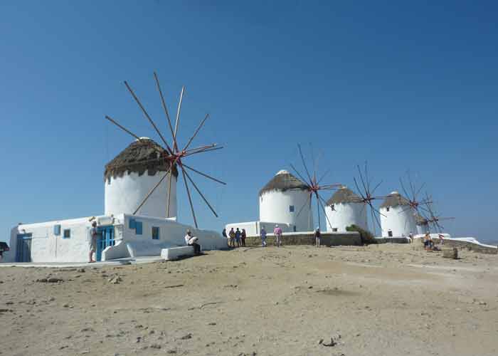 Alignement des moulins  vent de Mykonos sur une colline en bord de mer sous un ciel bleu clatant