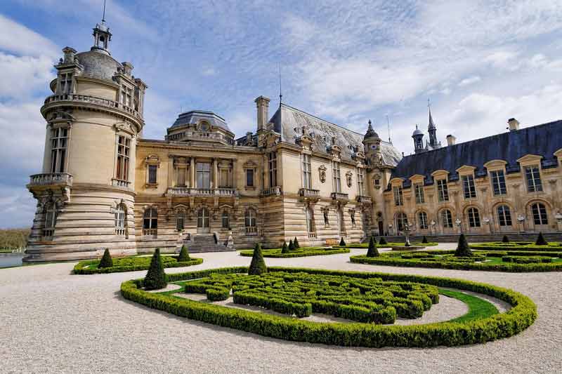 Vue de la façade et des jardins à la française du château de Chantilly, dans l'Oise