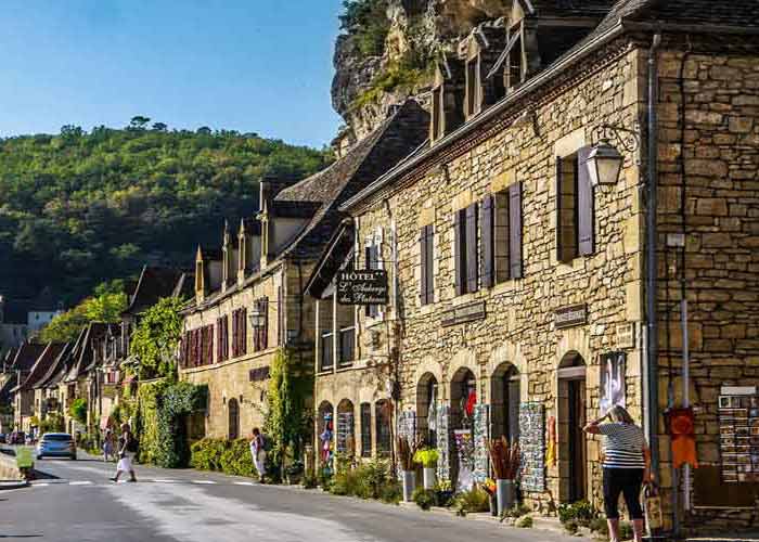 Maisons en pierre typiques du Prigord bordant la rivire, sous le soleil du sud-ouest de la France