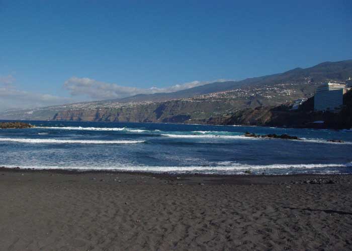 Plage de sable noir de Playa de la Arena � Tenerife, bord�e par les vagues de l�Atlantique et les reliefs volcaniques de la c�te